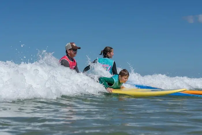 moniteur de surf dans l'eau avec les élèves à Biscarrosse plage du Viver
